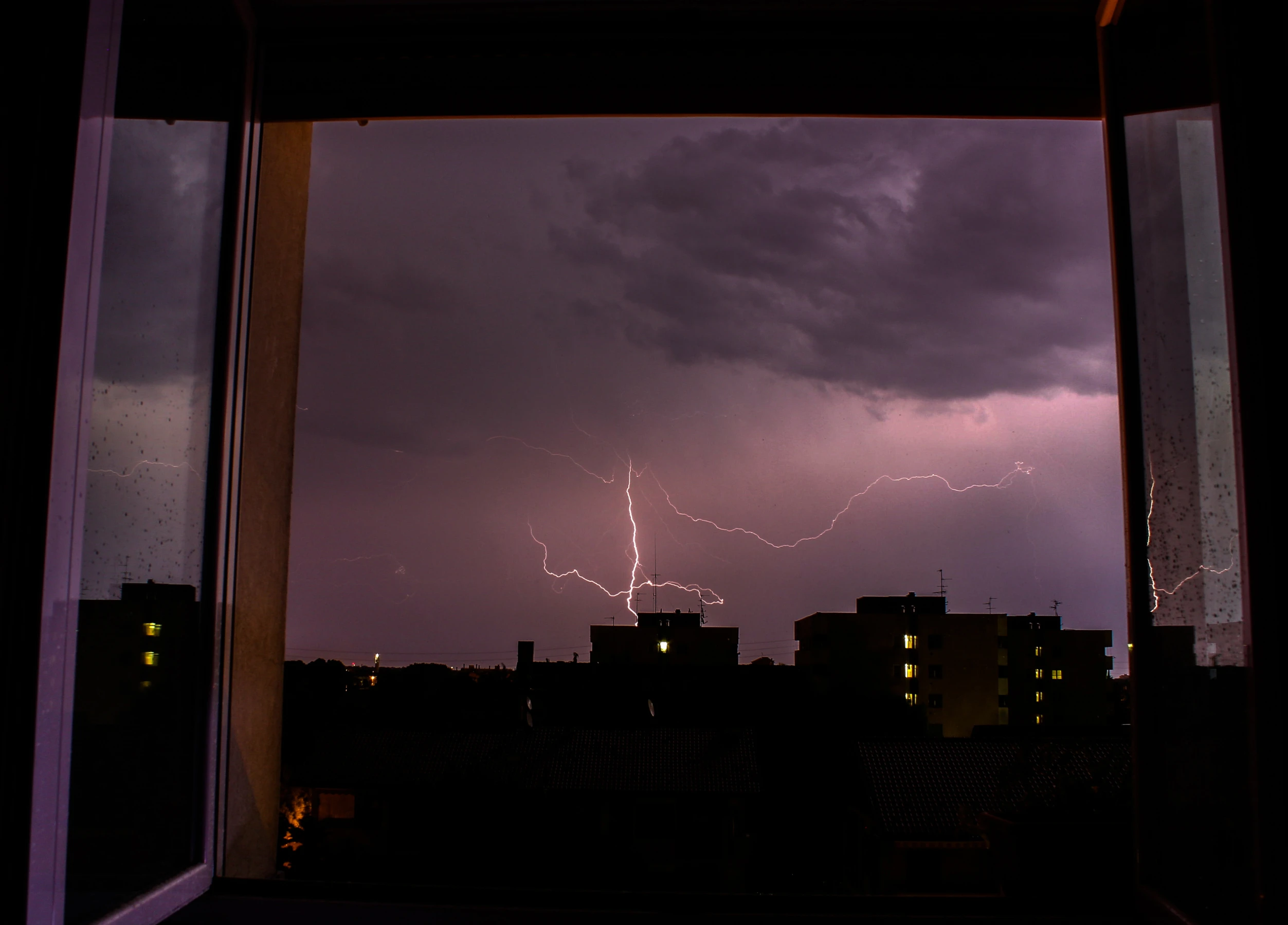 People observing a thunderstorm from indoors and learning about lightning